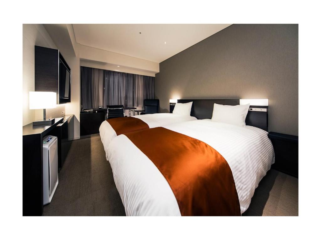 Postel nebo postele na pokoji v ubytování Daiwa Roynet Hotel Ginza PREMIER