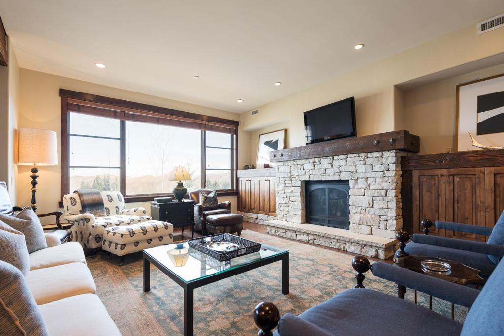a living room with a stone fireplace with a tv at Silver Star #1205 - 3 Bed Condo in Park City