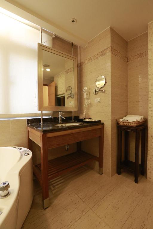 a bathroom with a sink and a mirror and a tub at Jingan Classic Inn in Zhonghe