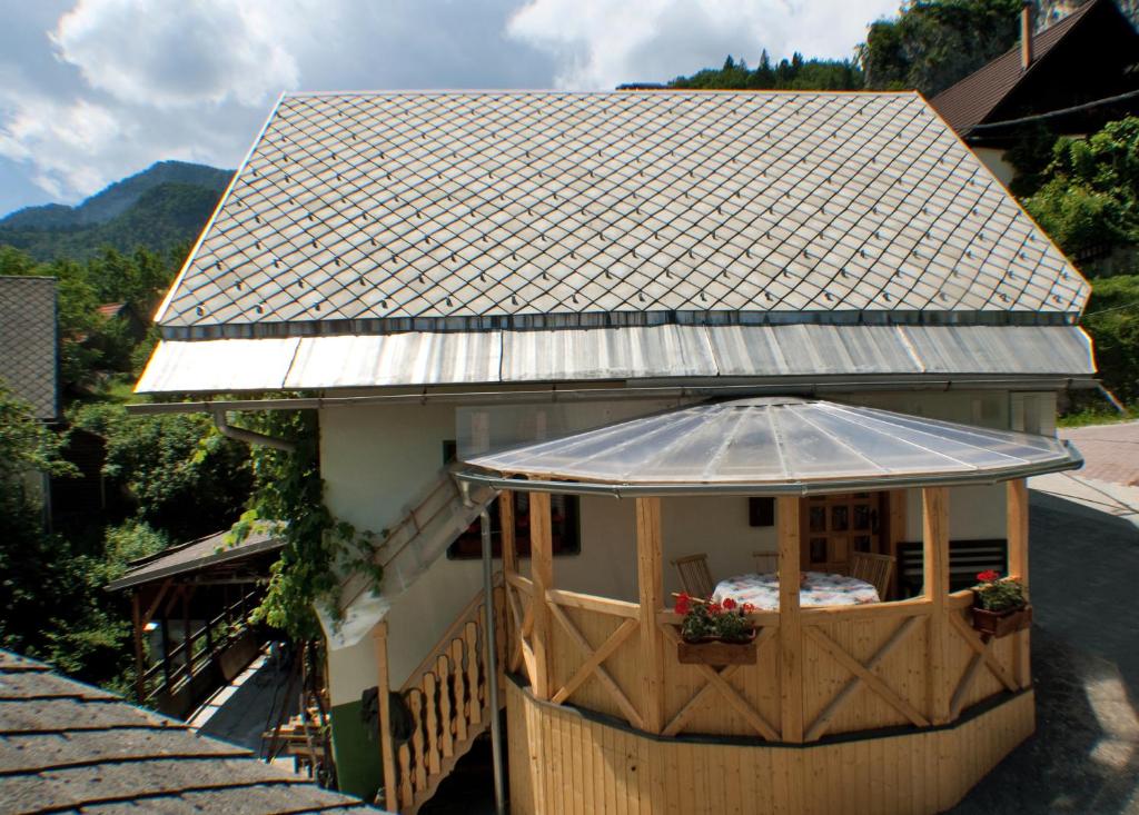 Cette petite maison dispose d'une terrasse couverte avec un parasol. dans l'établissement Apartments Torkar, à Bled