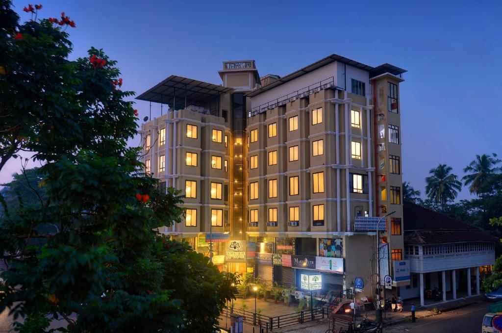 a large building with lights on in a city at TreeHouse Neptune Inn in Panaji