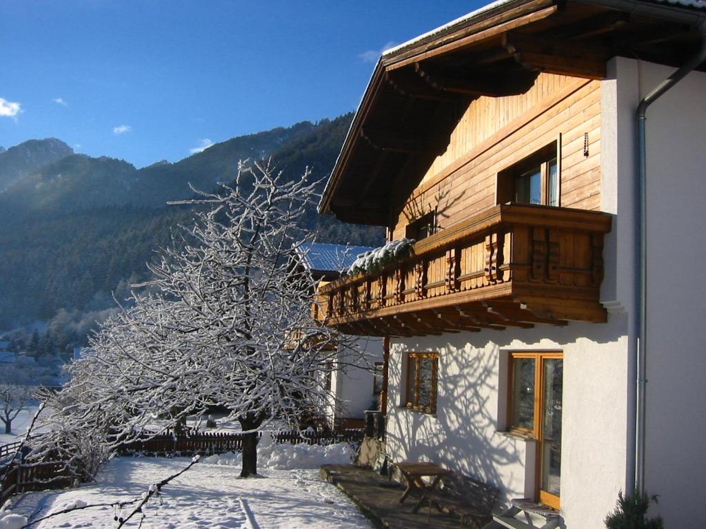 プフンツにあるFerienhaus Köhleの雪の中の木とバルコニー付きの建物