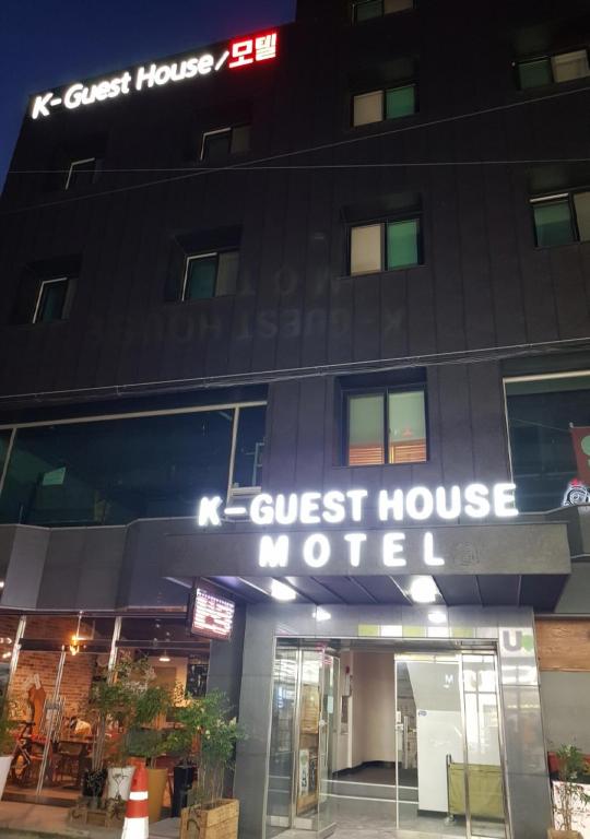 a guest house motel sign in front of a building at K Guesthouse in Gangneung