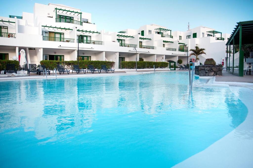 a large swimming pool in front of a building at Apartamentos El Guarapo in Costa Teguise