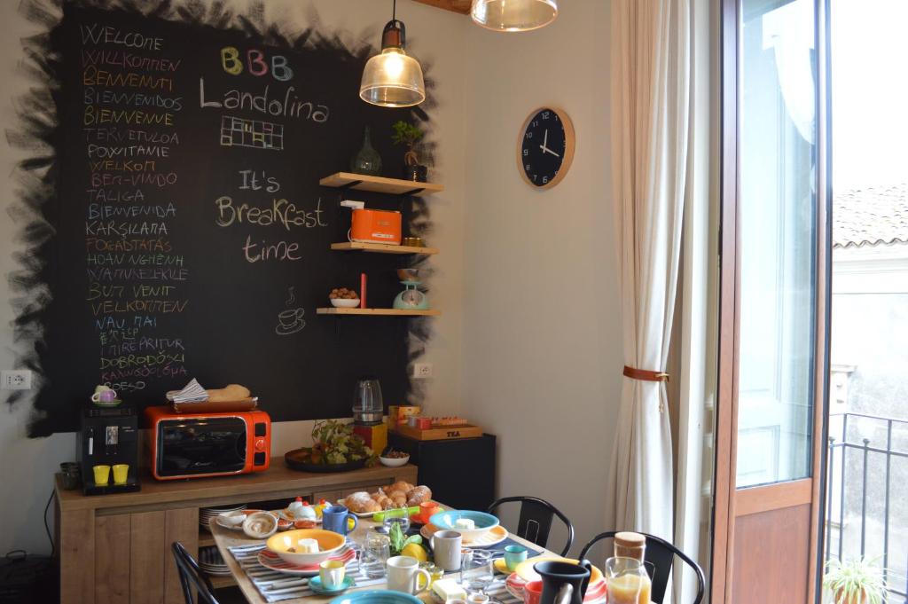 - une table avec de la nourriture dans une pièce dans l'établissement Bed, Book & Breakfast Landolina, à Catane