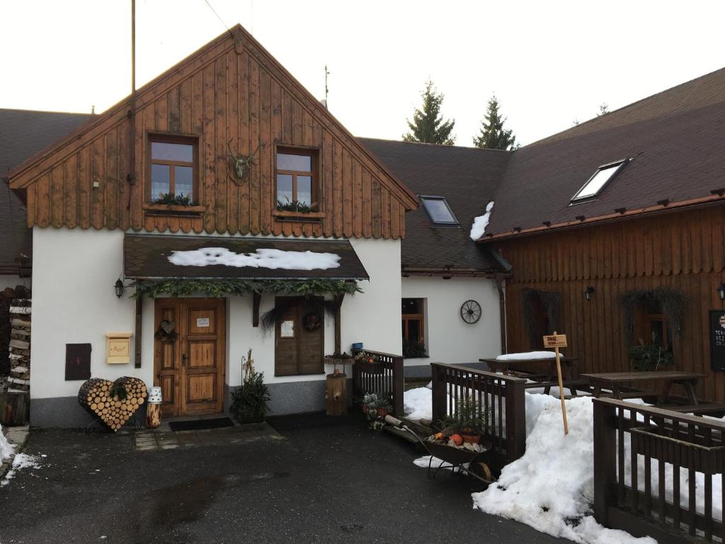una casa con nieve en el suelo delante de ella en Česká Chalupa, en Liberec
