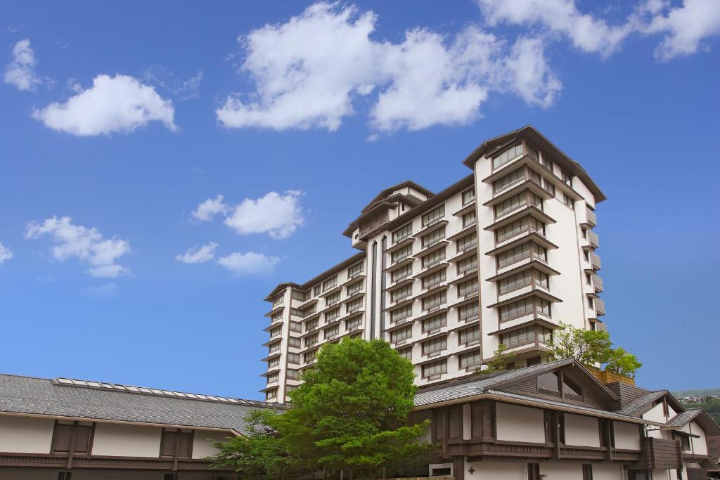 a tall white apartment building against a blue sky at Hamanoyu in Suwa