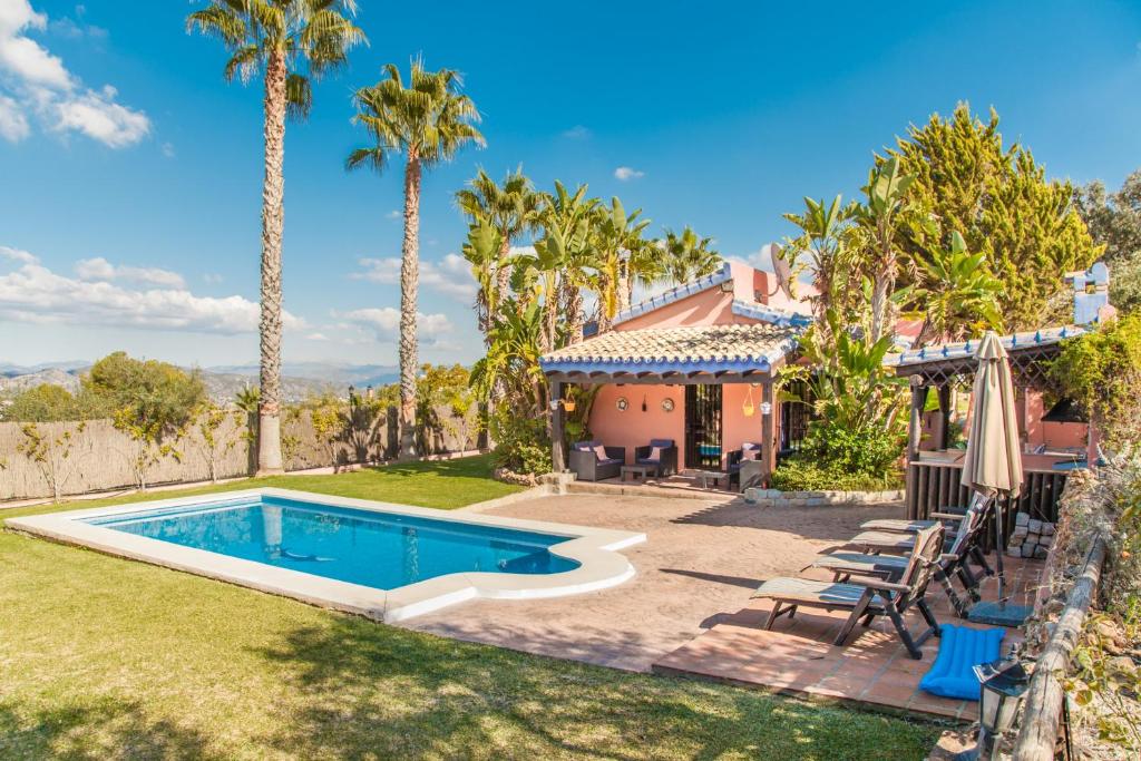 ein Haus mit einem Pool und Palmen in der Unterkunft Finca la Encina in Alhaurín de la Torre