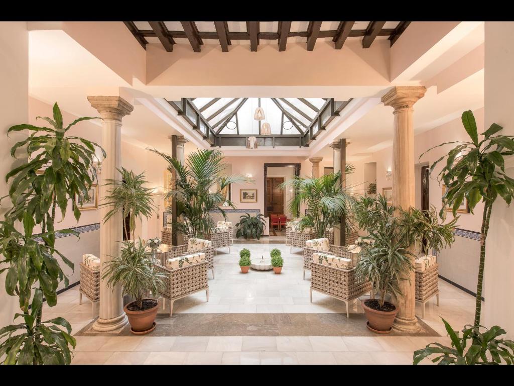 a lobby with chairs and potted plants in a building at Anacapri in Granada