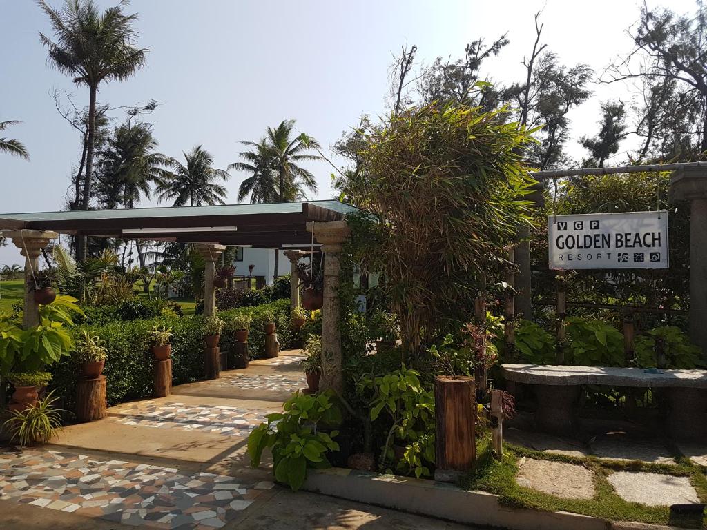 Vgp Golden Beach Resort في تشيناي: جناح حديقة مع وجود علامة وبعض النباتات