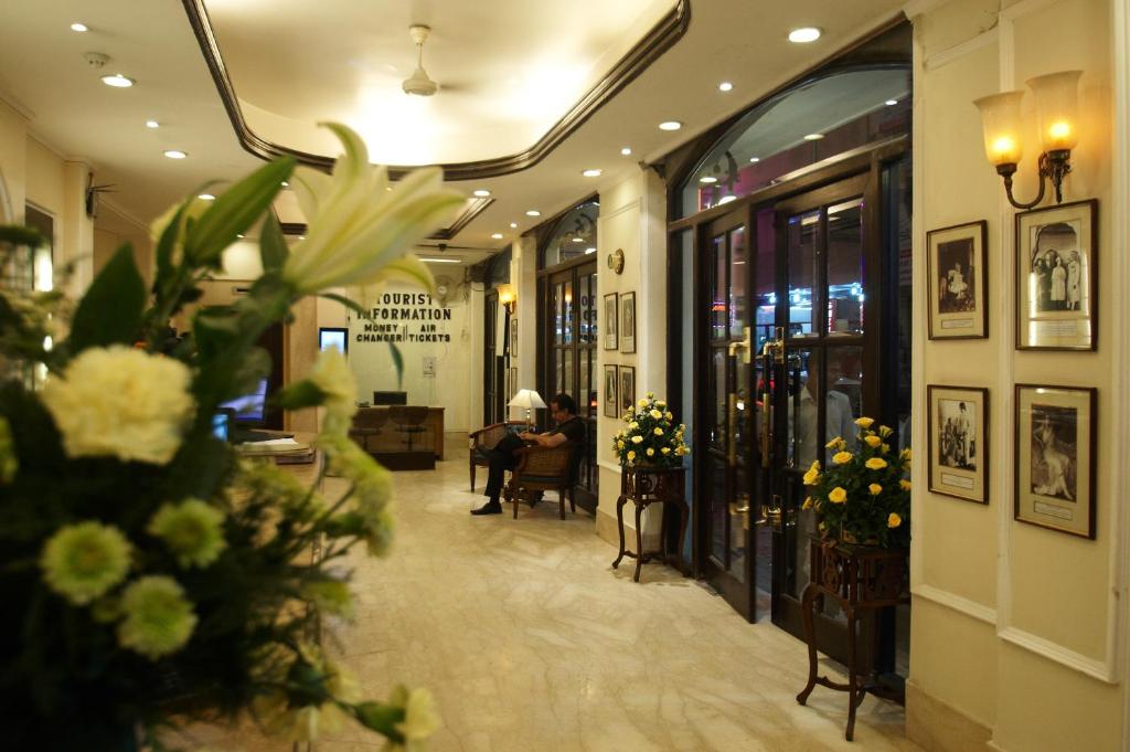 a woman sitting at a table in a lobby at Hotel Ajanta in New Delhi