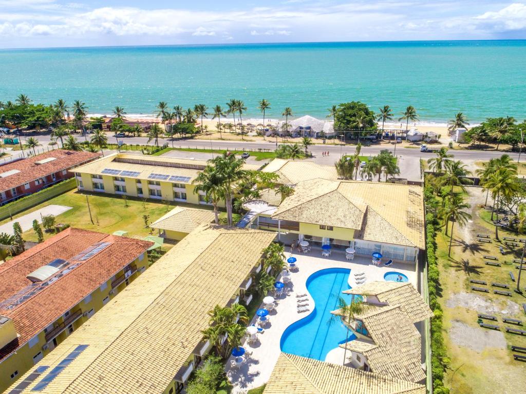 an aerial view of a resort with a pool and the ocean at Sunshine Praia Hotel in Porto Seguro