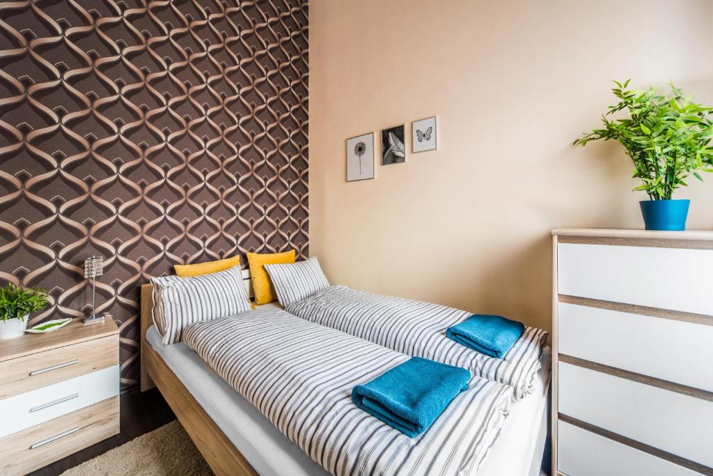 1 dormitorio con 1 cama con almohadas a rayas y pared en KIRÁLY 38 2BEDROOM AIRCON ENTIRE APARTMENT en Budapest