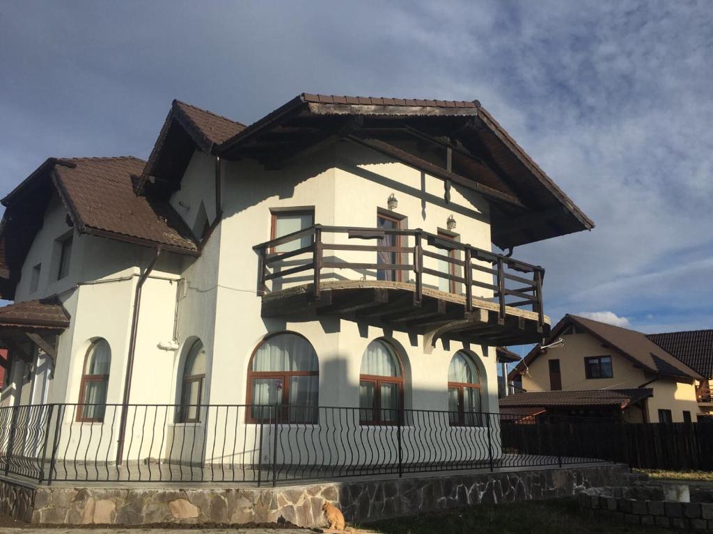 a large white building with a balcony on it at Apartament Ella in Râşnov