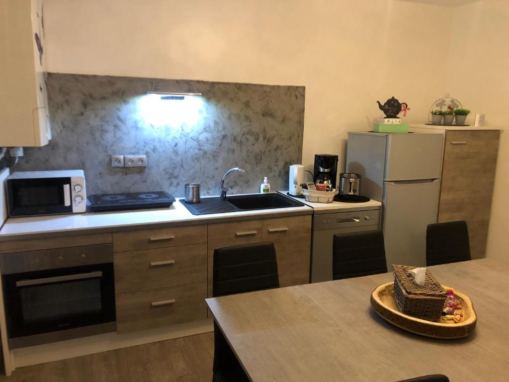 a kitchen with a sink and a refrigerator at Appartement tout confort Ugine in Ugine