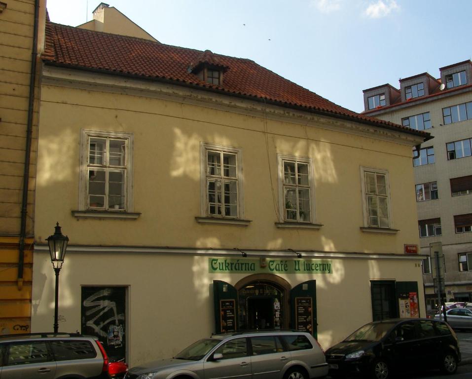 a white building with cars parked in front of it at Apartment Aida in Prague