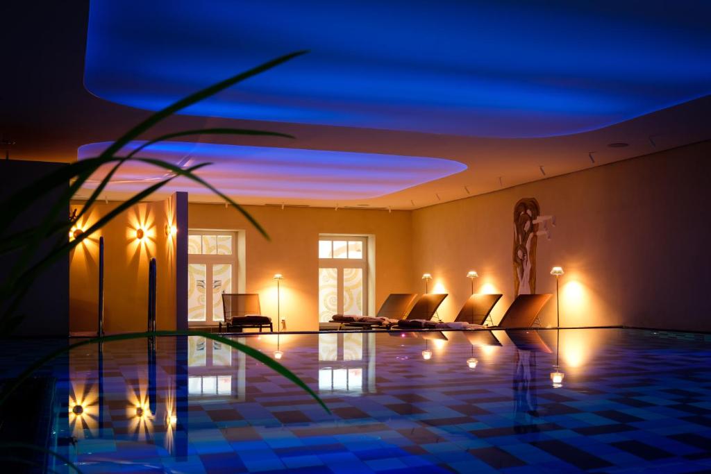 トラーベン・トラーバッハにあるロマンティック ユーゲントシュティルホテル ベルビューの夜間のスイミングプール付きのヴィラ