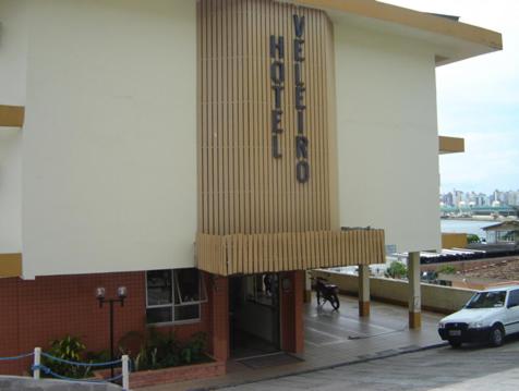 a building with a dog standing outside of it at Hotel Veleiro in Florianópolis