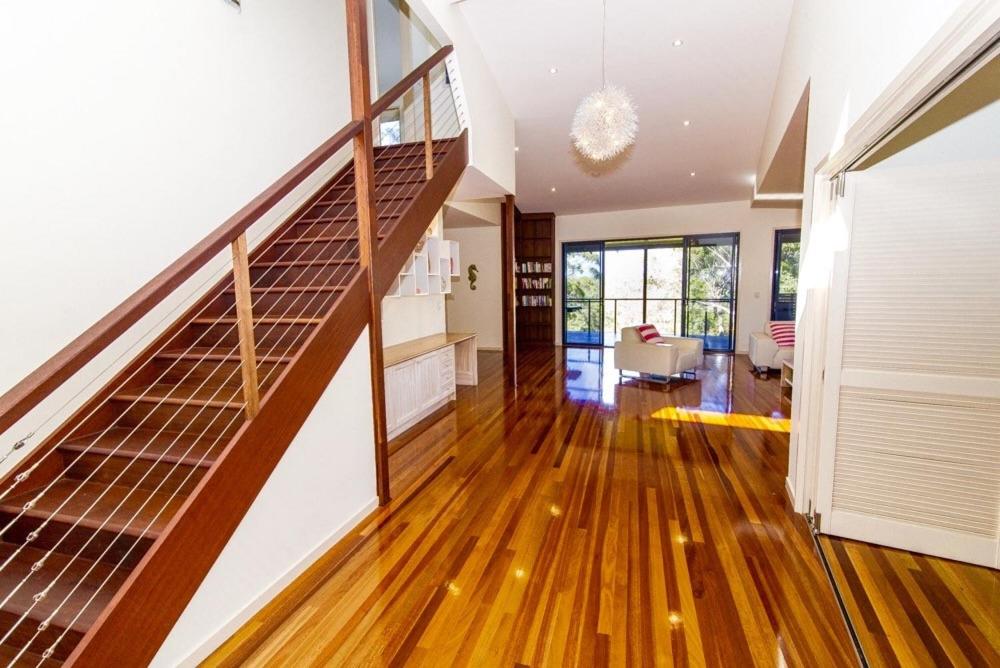 una sala de estar con una escalera en una casa en The Holiday House, en Fraser Island