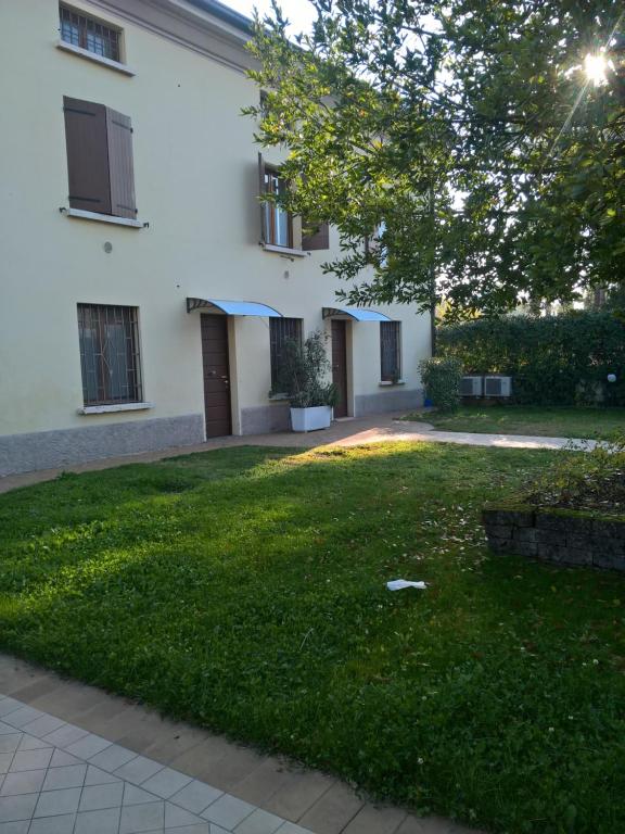 a yard of a building with a green lawn at Residence Buca di Bacco in Volta Mantovana