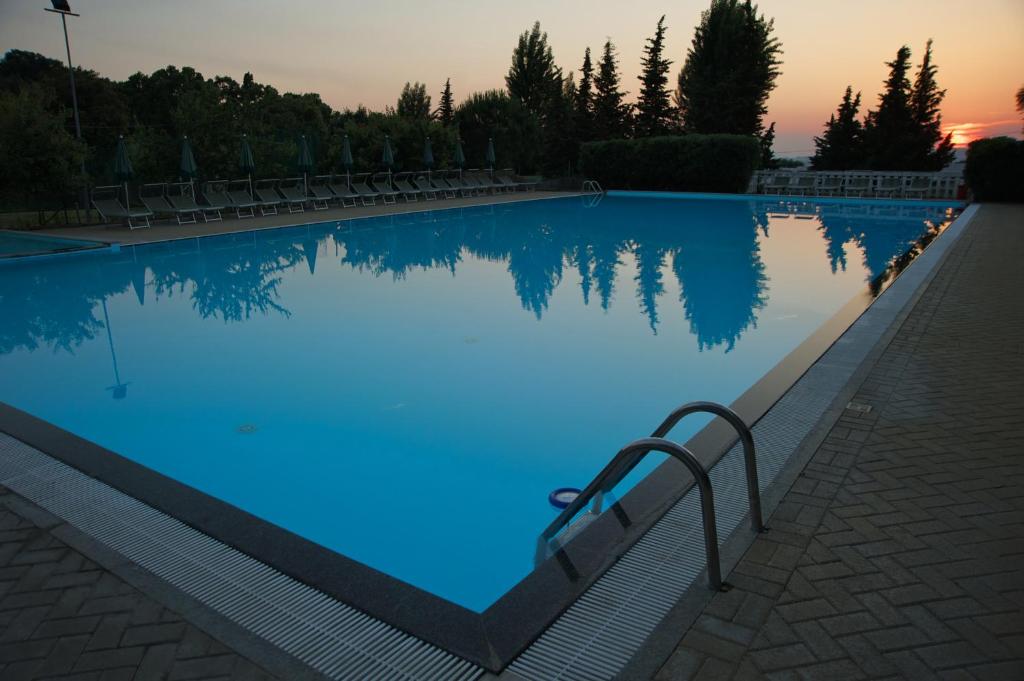 una gran piscina con iluminación azul en Villaggio Turistico Camping Il Fontino, en Scarlino