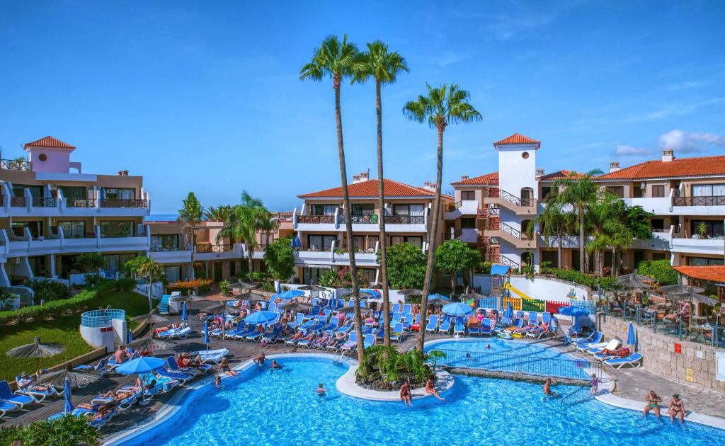 un complejo con una gran piscina y palmeras en Apartamentos Albatros Golf del Sur Tenerife en San Miguel de Abona