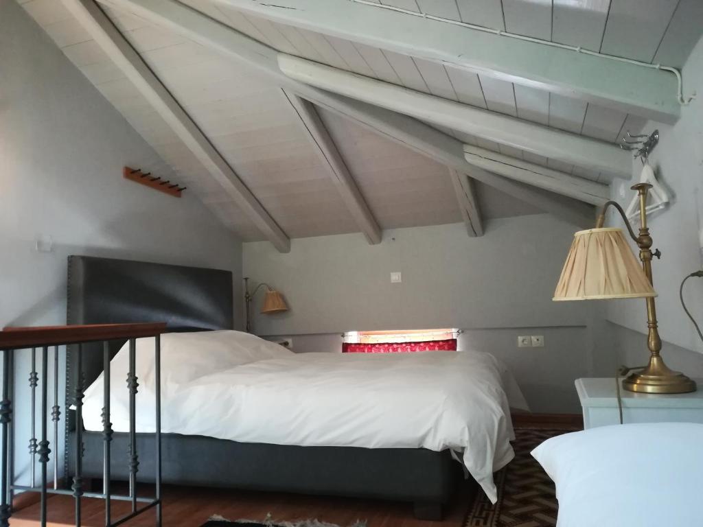 um quarto com uma grande cama branca e um candeeiro em Guest House Ioanna Arachova em Arachova