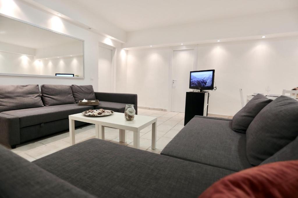 sala de estar con sofá, mesa y TV en Pretty Space, en Milán