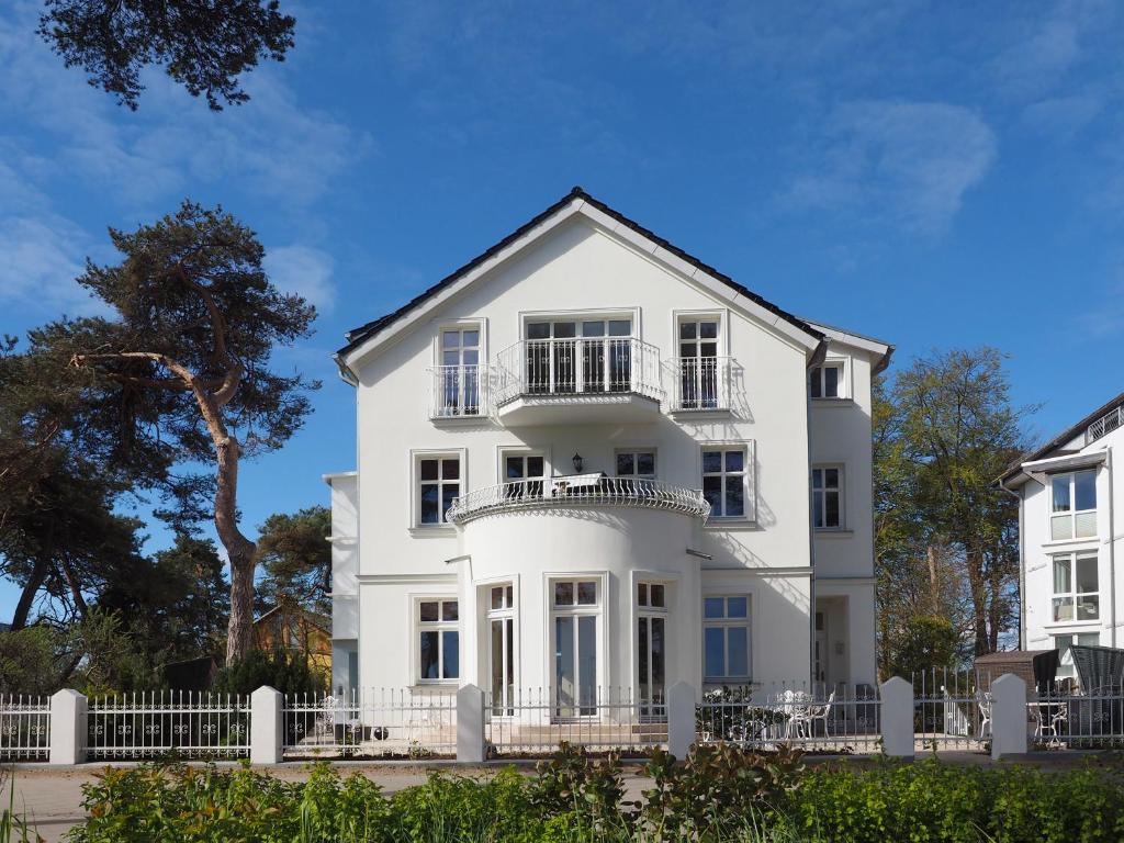 a white house with a white fence at Villa Desny in Bansin