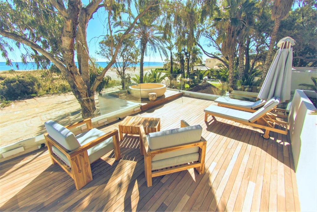 una terraza con sillas, una sombrilla y una mesa en Botaniq Hotel Boutique, en Mojácar