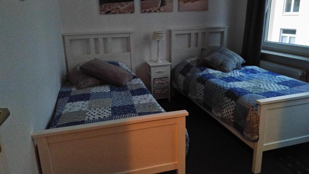 a bedroom with two twin beds and a window at Monteur & Fewo Sealoft in Wilhelmshaven