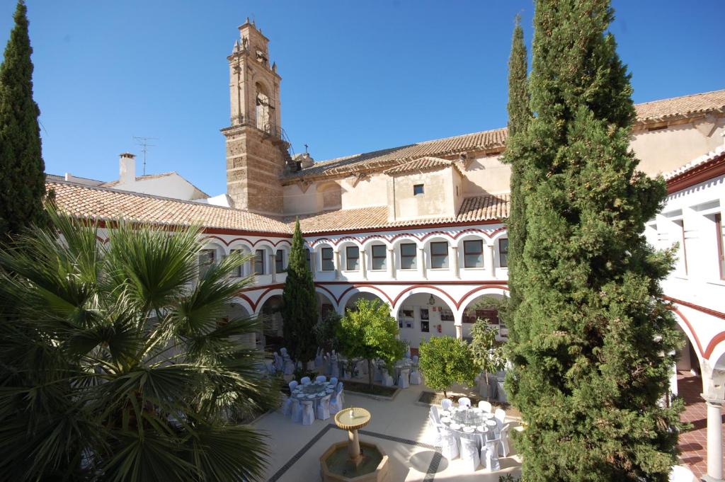 a courtyard of a building with a clock tower at Hotel Hospederia San Francisco in Priego de Córdoba