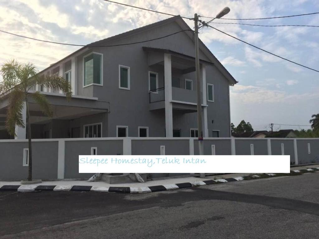 una casa con un cartello davanti di Sleepee Homestay a Teluk Intan