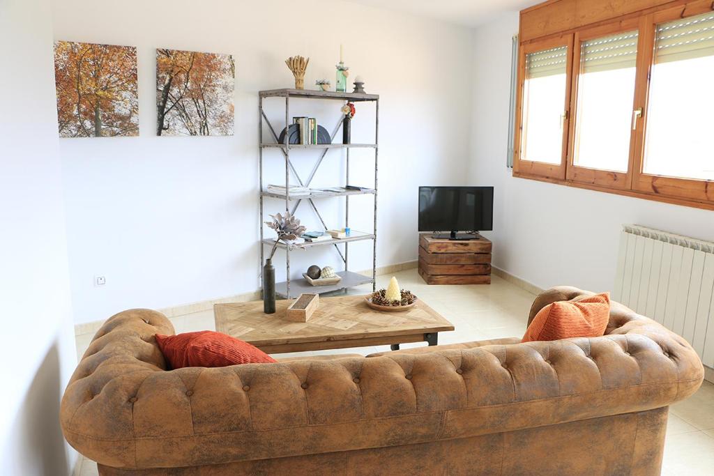 Cal Fasi في Torá de Rulbregos: غرفة معيشة مع أريكة بنية وطاولة
