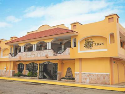 ein großes gelbes Gebäude mit einem Schild drauf in der Unterkunft Hotel Madan Cárdenas in Cárdenas