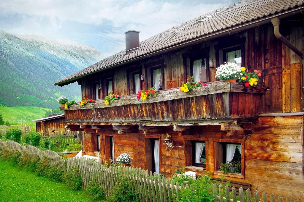 ein Holzhaus mit Blumen auf dem Balkon in der Unterkunft Ferienhaus Knor in Umhausen