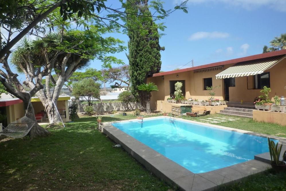 einen Hinterhof mit einem Pool und einem Haus in der Unterkunft Lagarto Hostel Tenerife in Valle de Guerra