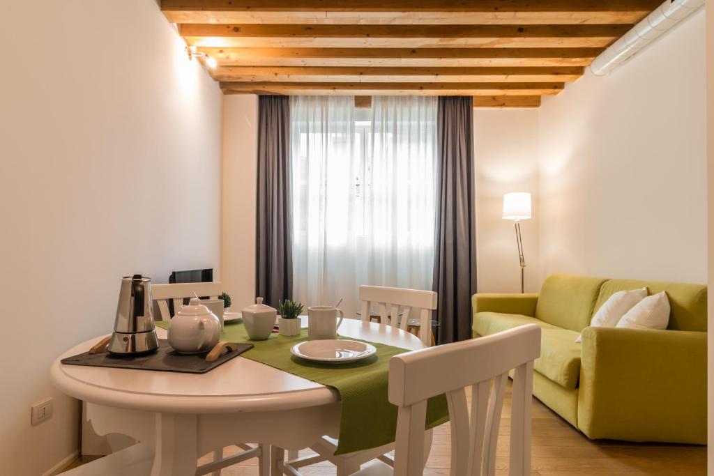 een woonkamer met een tafel en een gele bank bij Centrale Mazzoni 10 in Venetië