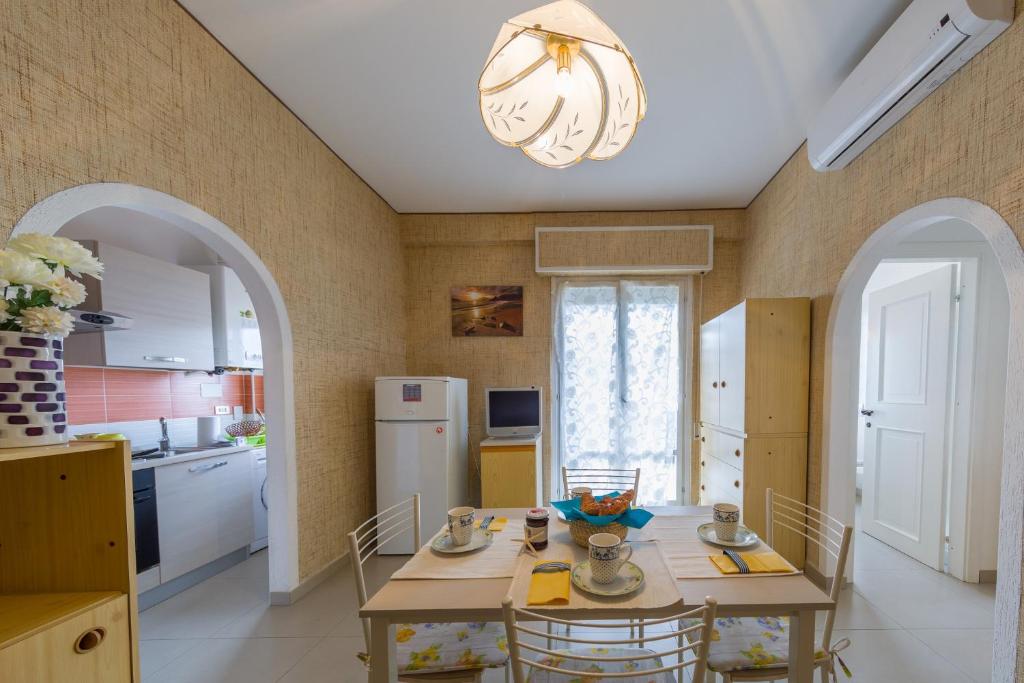eine Küche mit einem Tisch mit Stühlen und einem Kronleuchter in der Unterkunft Green Marine B16 Silvi Vacanza in Silvi Marina