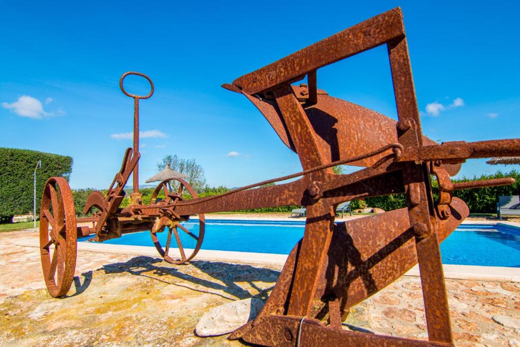 un cañón de metal oxidado sentado junto a una piscina en Agroturismo Petit Hotel Son Perdiu - Adults Only, en Sa Ràpita