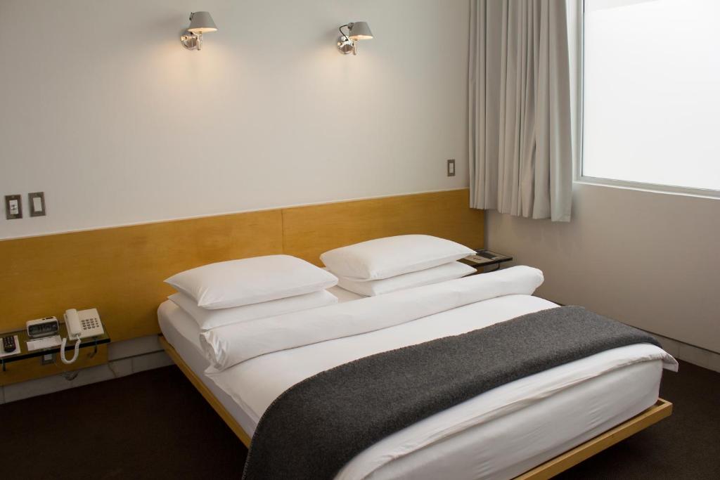 a bed with two pillows on it in a room at Habita, Mexico City, a Member of Design Hotels in Mexico City