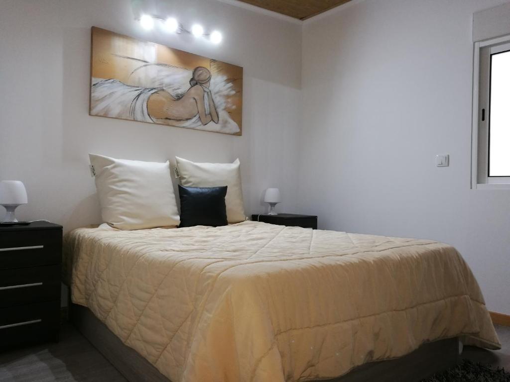 a bedroom with a bed and a painting on the wall at Panoramic Views in Caniço