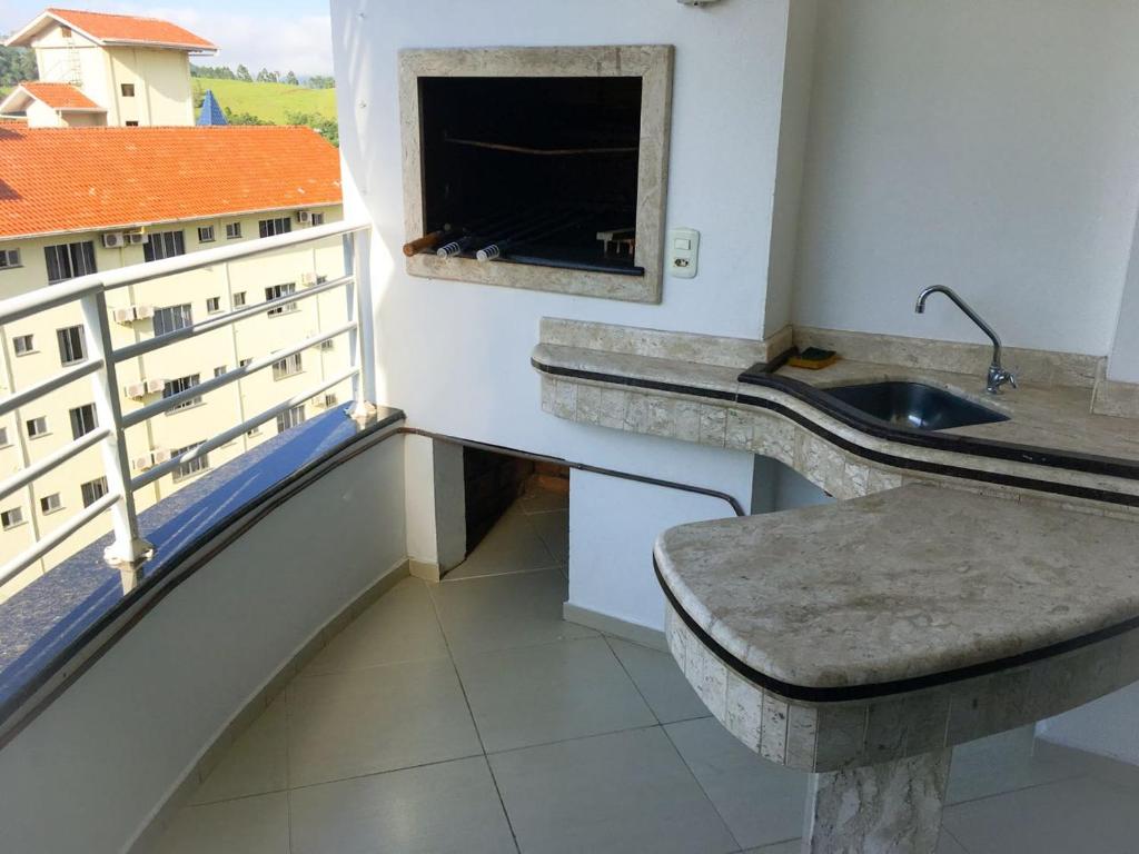 een badkamer met een wastafel en een raam bij Edifício Summer Ville in Piratuba