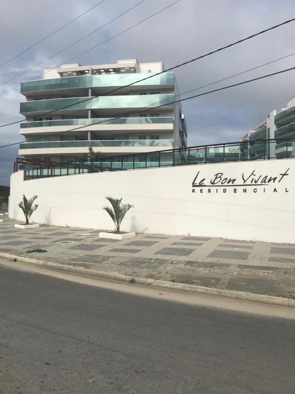 un edificio blanco con un cartel en el costado en Apartamento Super Luxo em Arraial do Cabo, en Arraial do Cabo