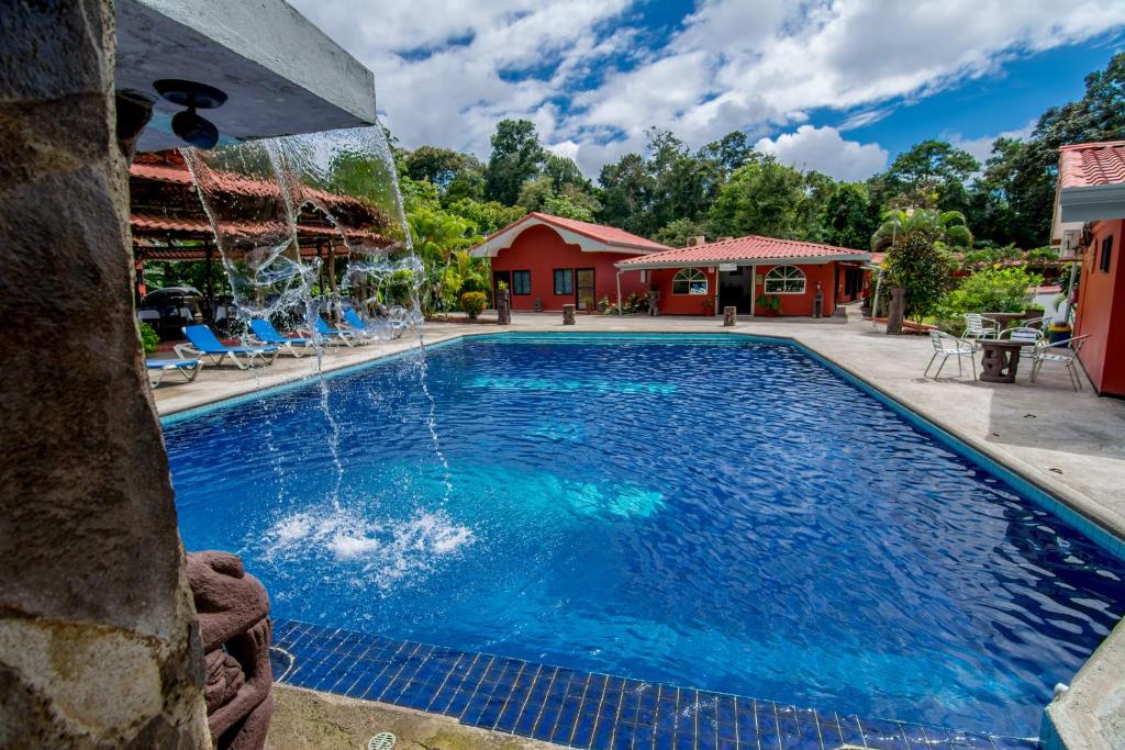 duży basen z niebieską wodą na dziedzińcu w obiekcie Pacific Paradise Resort w mieście Quepos