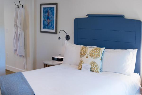 a bedroom with a large bed with a blue headboard and pillows at Indian Springs Resort & Spa in Calistoga