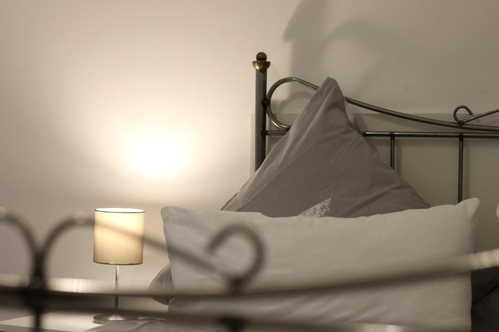 a bed with white sheets and a lamp and a pillow at Rentaroom-Kassel in Kassel