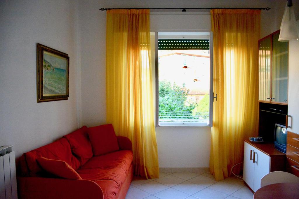 een woonkamer met een rode bank en een raam bij Casa Del Pruno in Monterosso al Mare