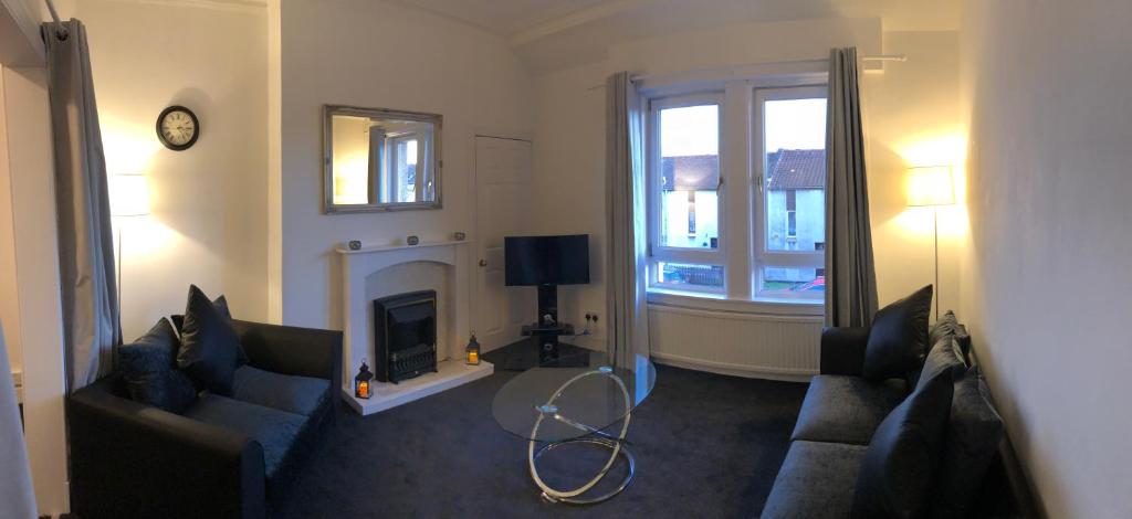 sala de estar con 2 sofás y chimenea en Wellesley Apartment en Leven-Fife
