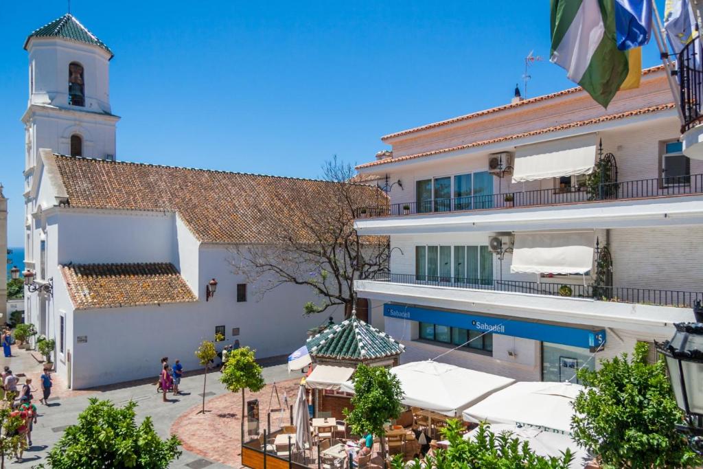 a building with a clock tower in a city at Canovas Nerja - Balcón de Europa in Nerja